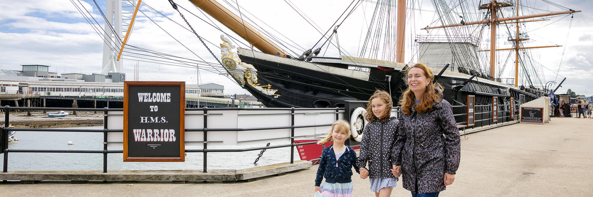 Una famiglia che cammina accanto a una nave in un molo