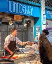A fishmonger serving a customer at Grainger Market in Newcastle
