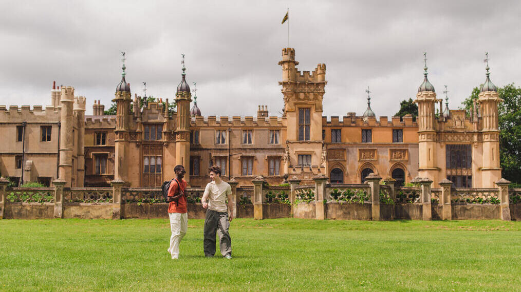 Two young men walk in the grounds of a heritage house