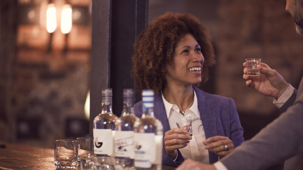 Una coppia che degusta whisky con tre bottiglie davanti a sé