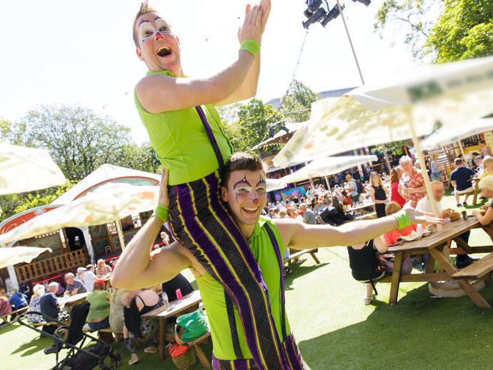Two acrobats strike a pose at a summer festival