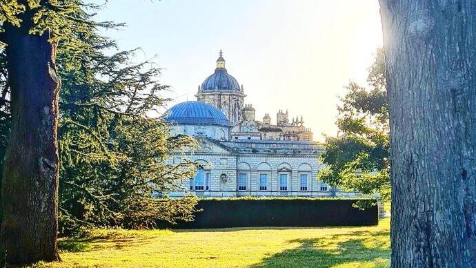 Historic mansion surrounded by trees and garden