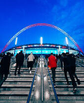 Group of people walking up the stairs of Wembley Stadium