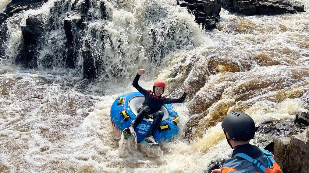 A woman rafting down some rapids at Endless Adventure North East in Newcastle