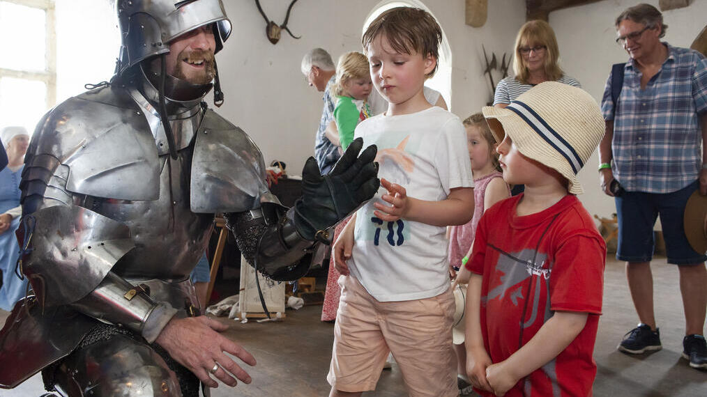 Un artiste en armure posant avec deux enfants au château de Bolton dans le Yorkshire