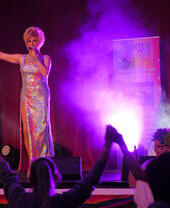 A performer on stage in front of a crowd at Pride Blackpool