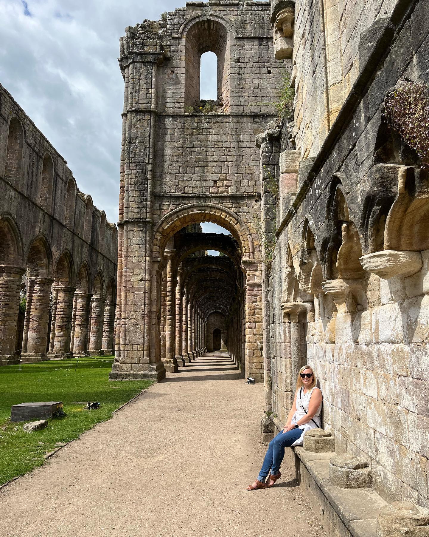 Eine Dame vor der Fountain Abbey im Studley Royal Park