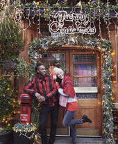 Couple in front of a pub entrance covered with Christmas decorations