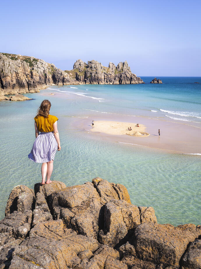 Woman standing on a rock looking out to sea