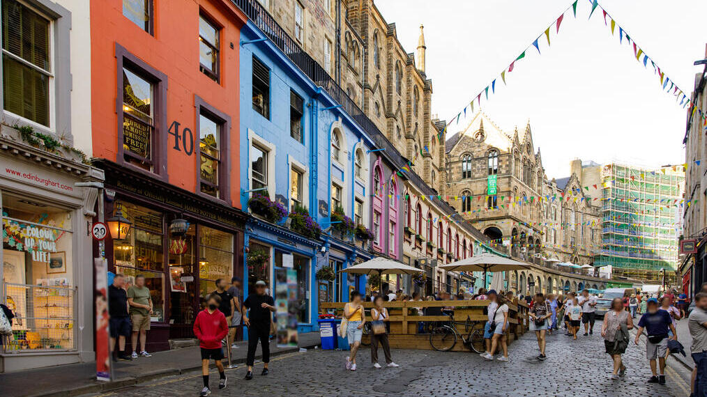 People walking in a street in a city lined with shops