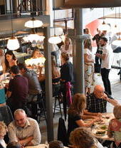 Des groupes de personnes assises à des tables à l'intérieur du Maray, un restaurant situé dans le quartier animé des docks de Liverpool
