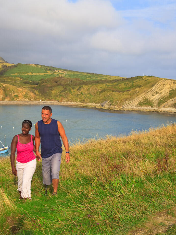 A couple walking on the clifftop.