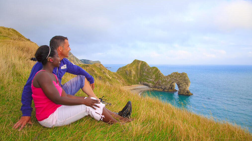 Couple assis sur l'herbe regardant la mer