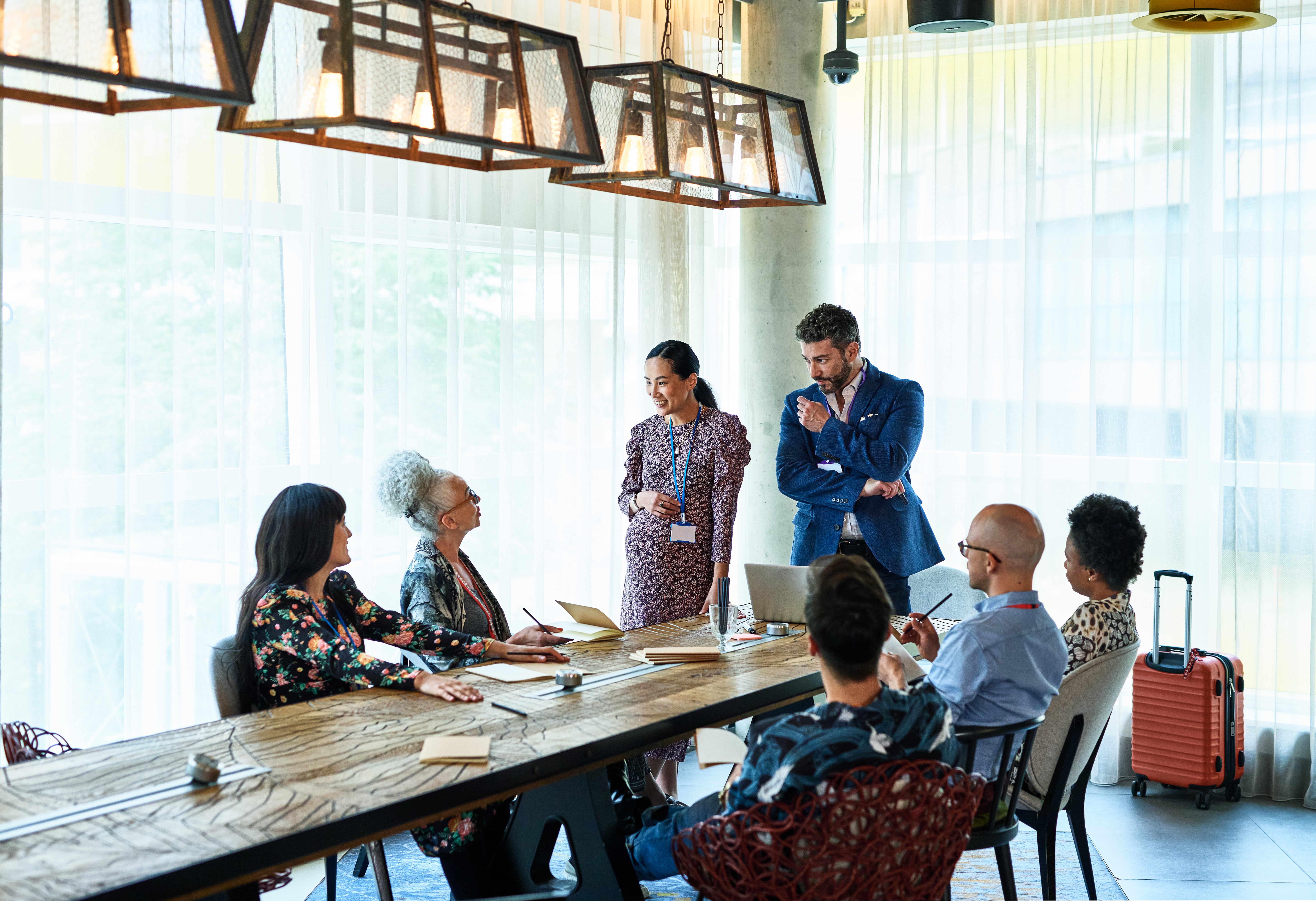 People having a meeting at a long table in a conference venue