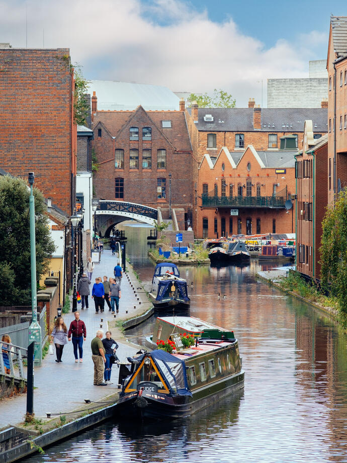 Canal boats and a towpath running alongside a canal in a city