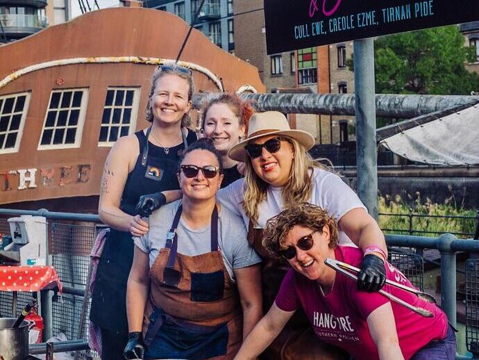 Group of ladies in aprons Hangfire Bbq cooking at Meatopia Food Festival