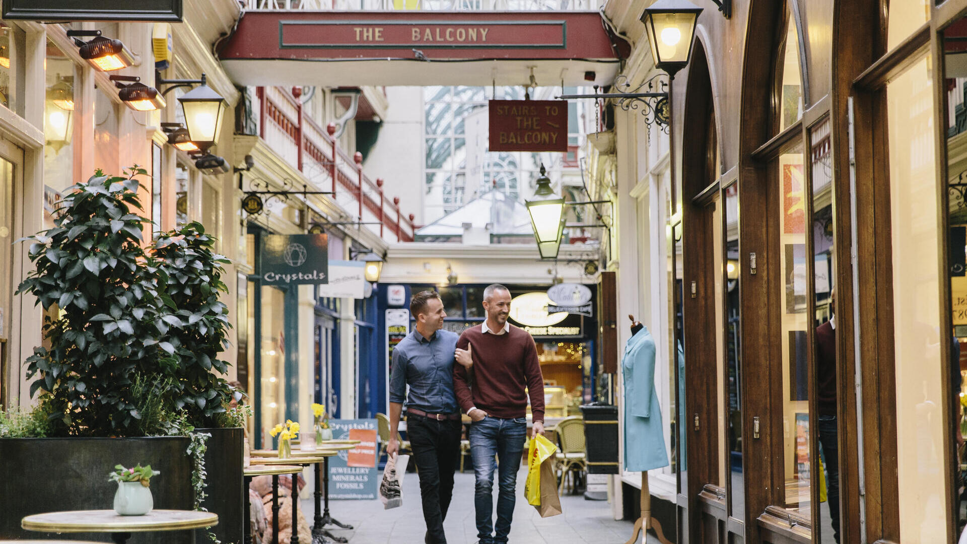 A gay couple, with arms linked, shopping indoors