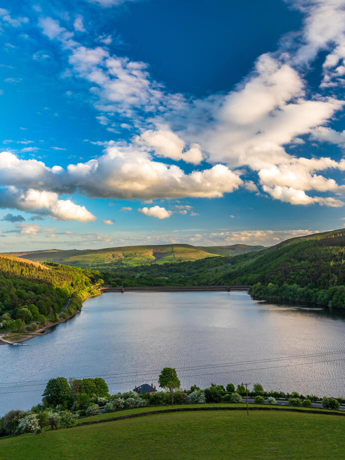 A view over a reservoir with sweeping green hills