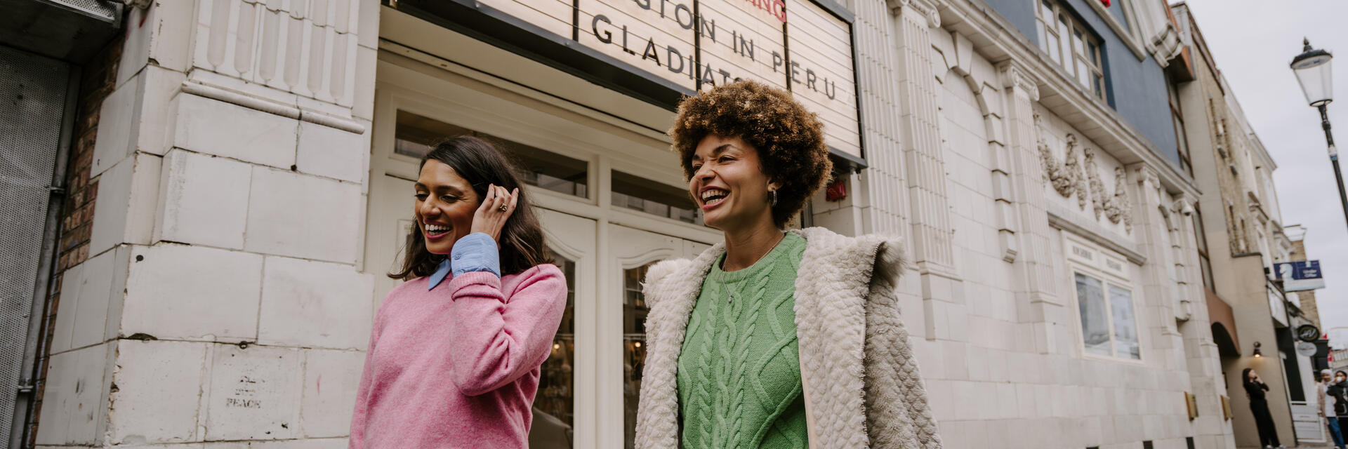 Two women leaving a retro cinema.