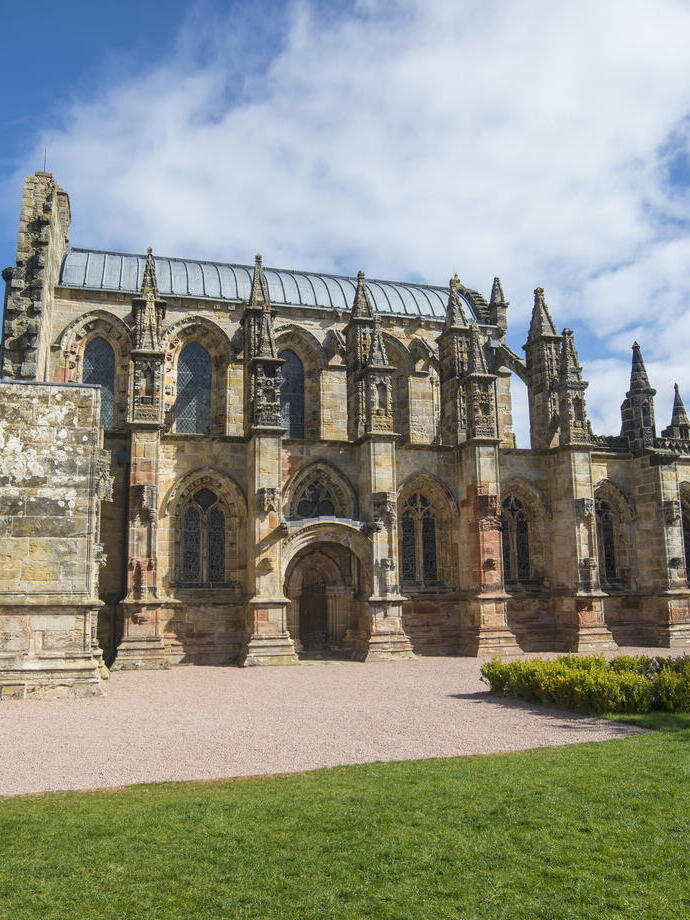 Exterior view of the remains of a Medieval chapel on a sunny day.