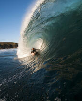 Homme surfant sur une vague géante dans la mer