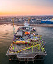 Un muelle junto al mar y un parque de atracciones.
