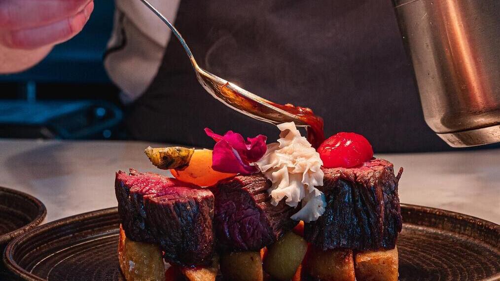 Koch serviert ein Bratenessen