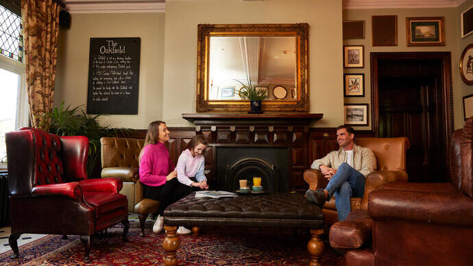 Family of three sitting and talking by the fireplace at a local pub.