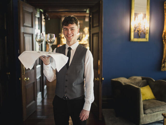 Medewerker met een dienblad met twee glazen wijn in een restaurant