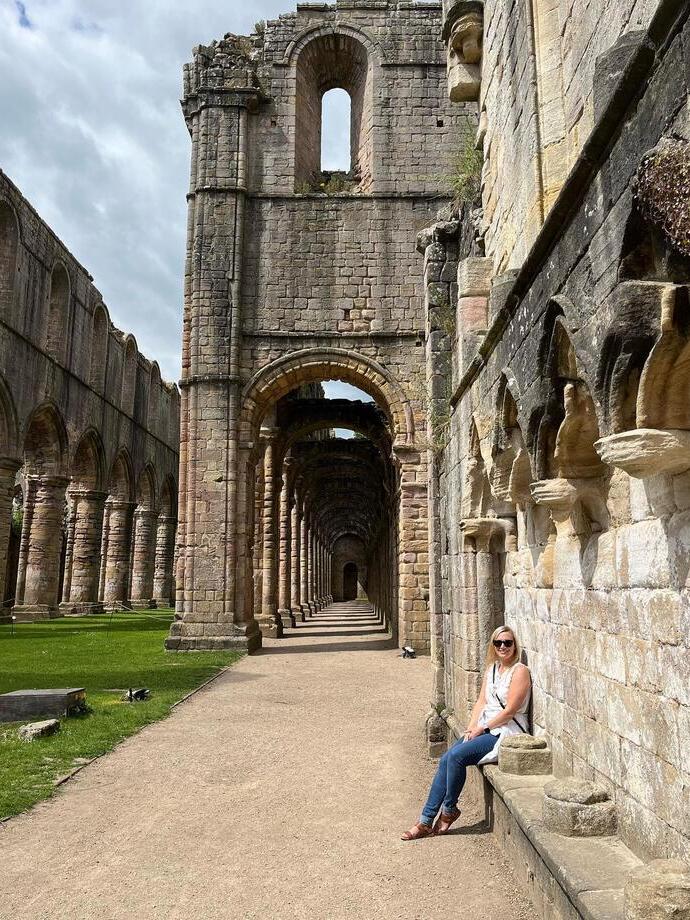 Una signora fuori dalla Fountain Abbey allo Studley Royal Park