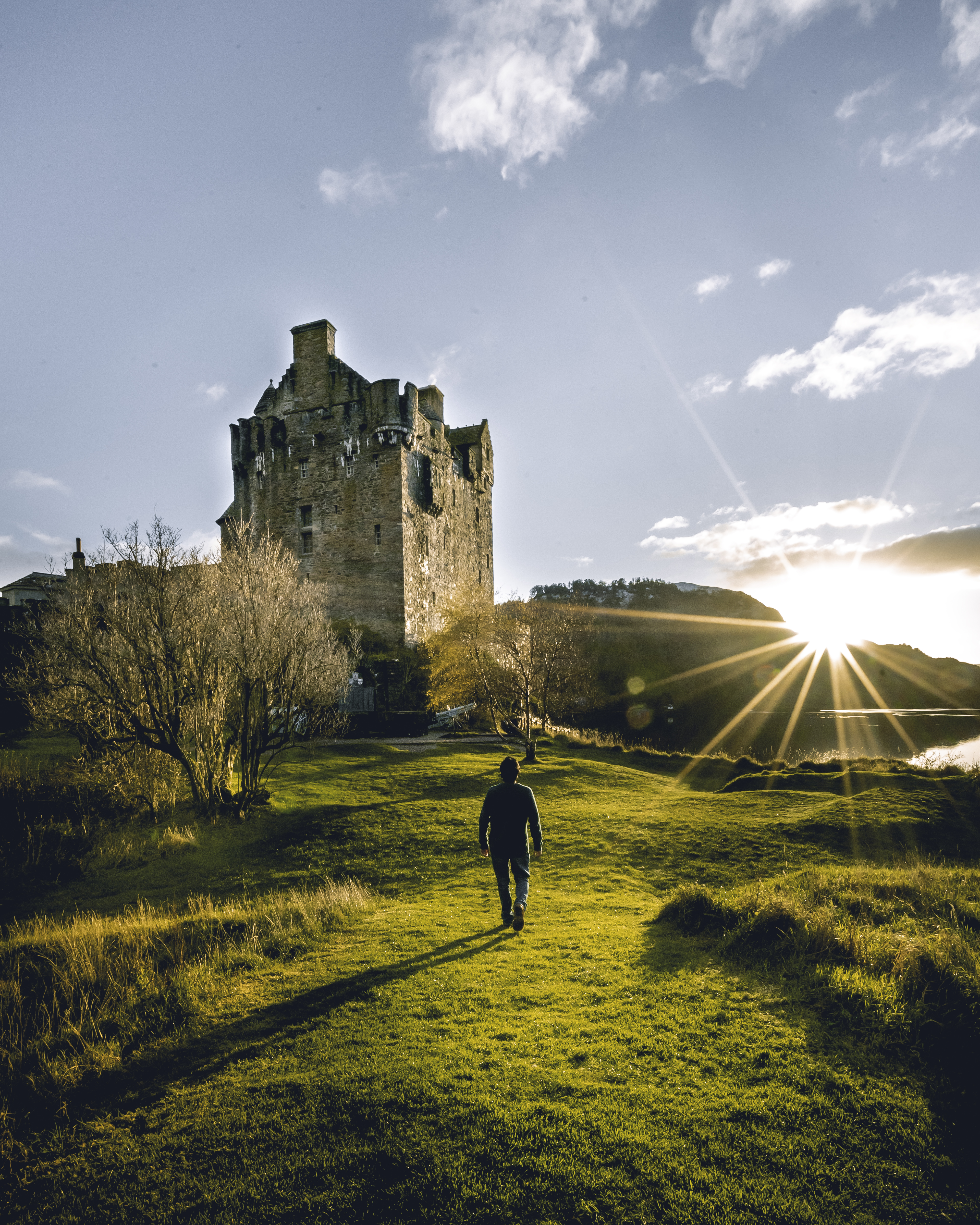 Man walking towards a castle at sunrise