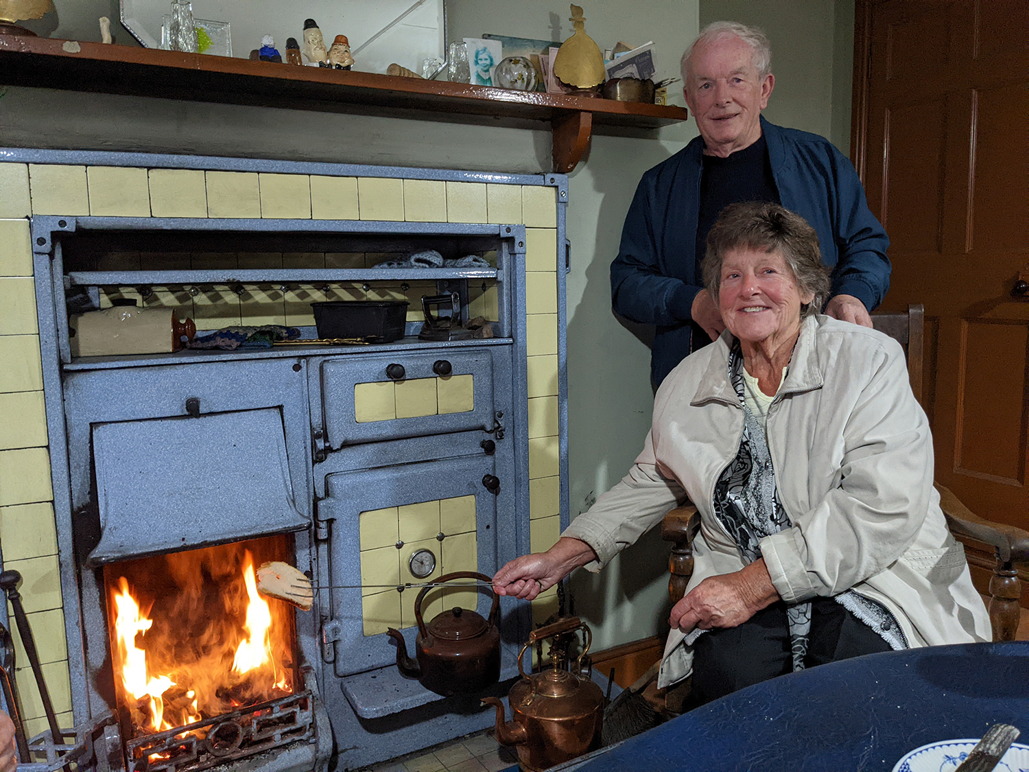 Elderly couple by a fireplace in an historic living museum
