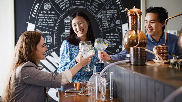 Man and two women, one in a wheelchair sitting in a bar at a gin tasting distillery experience