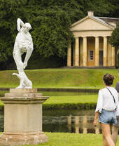 A young couple walking through the grounds of Fountains Abbey and Studley Royal Water Garden, North Yorkshire