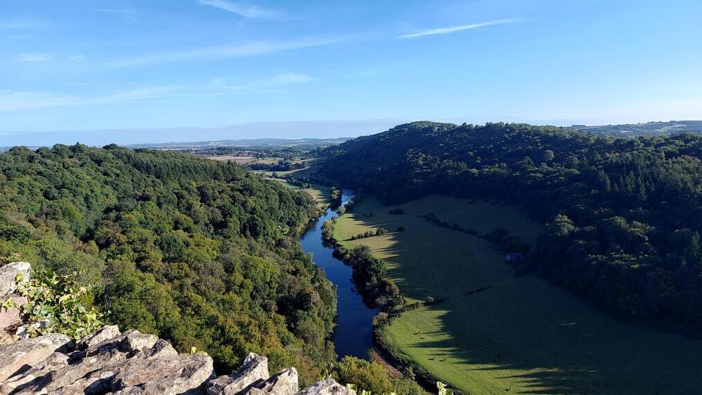 A rocky outlook surrounded by trees with a river below.