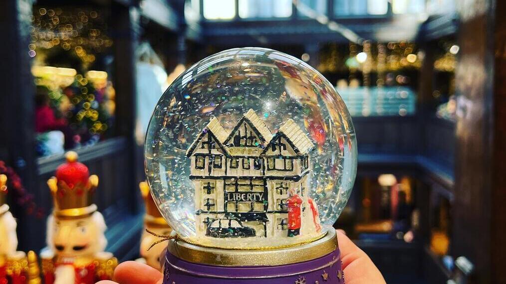 Holding a snow globe at Liberty London