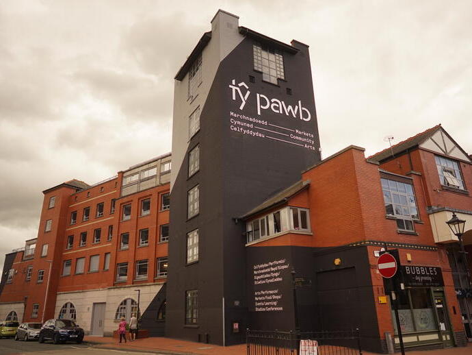 Exterior view of a building with a sign that reads 'Ty Pawb'.