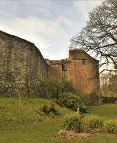 Exterior of a red-brick castle and fortified wall in winter.