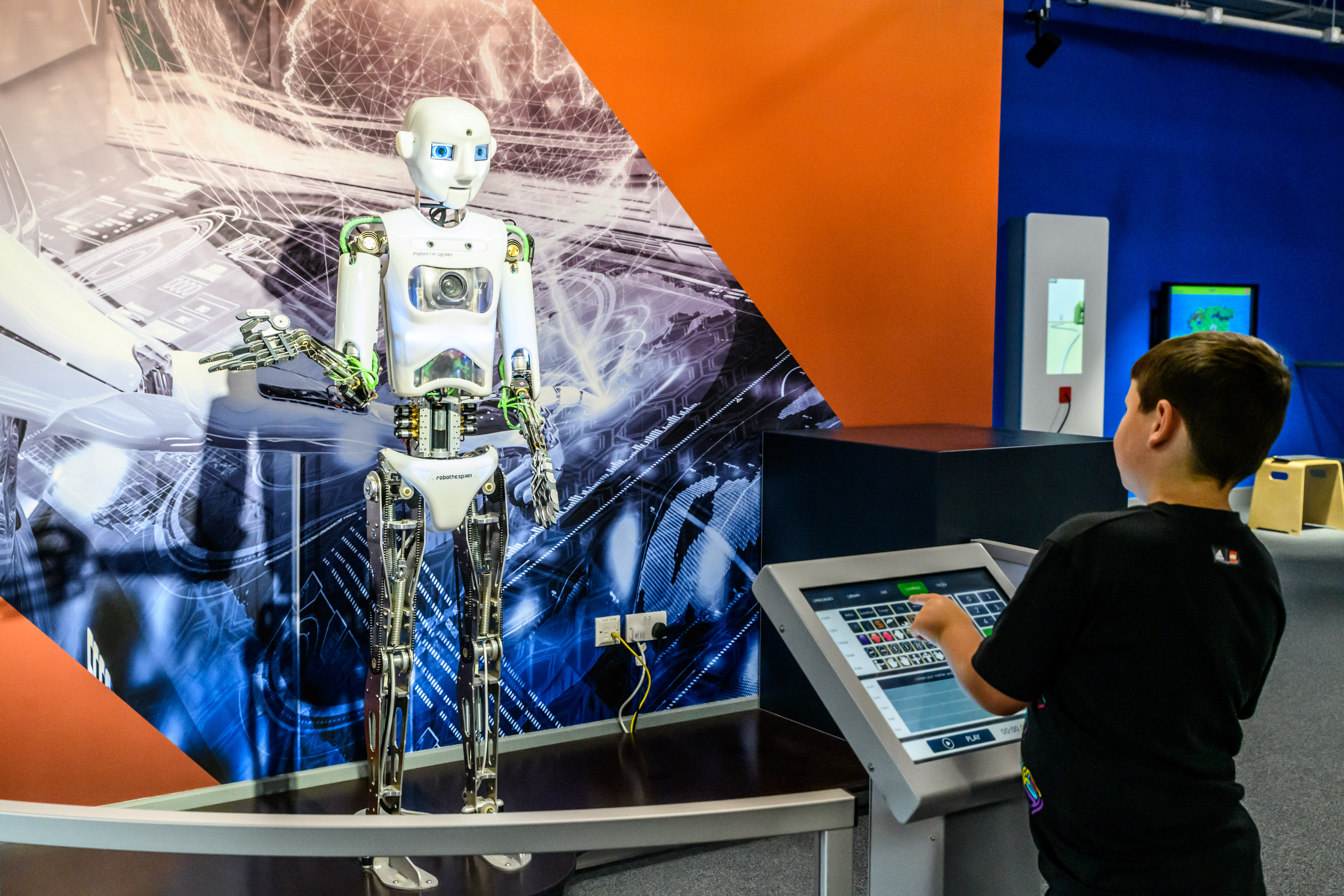 A child playing with an interactive exhibit at a science museum.