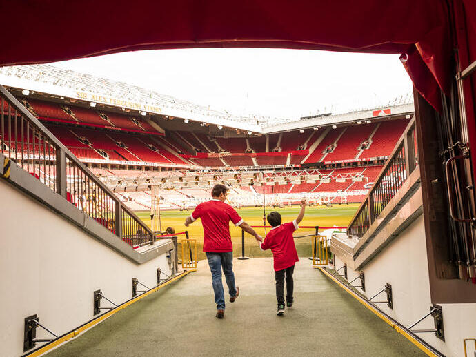 Un homme et un garçon dans le tunnel d'un stade regardant vers le terrain