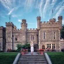 Young woman standing on terrace in front of castle