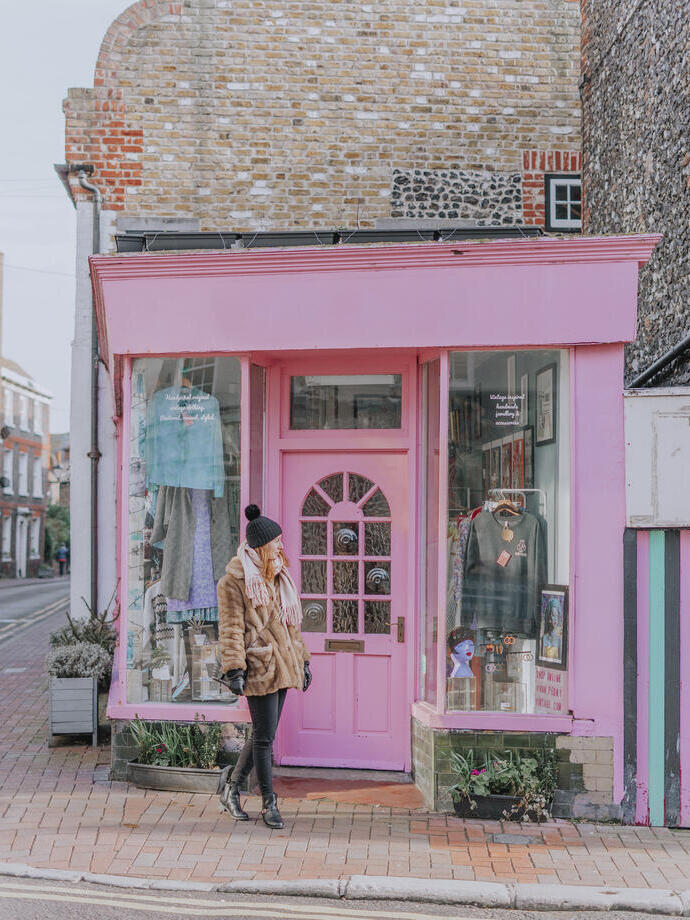 Woman walking in front of a vintage clothing shop 