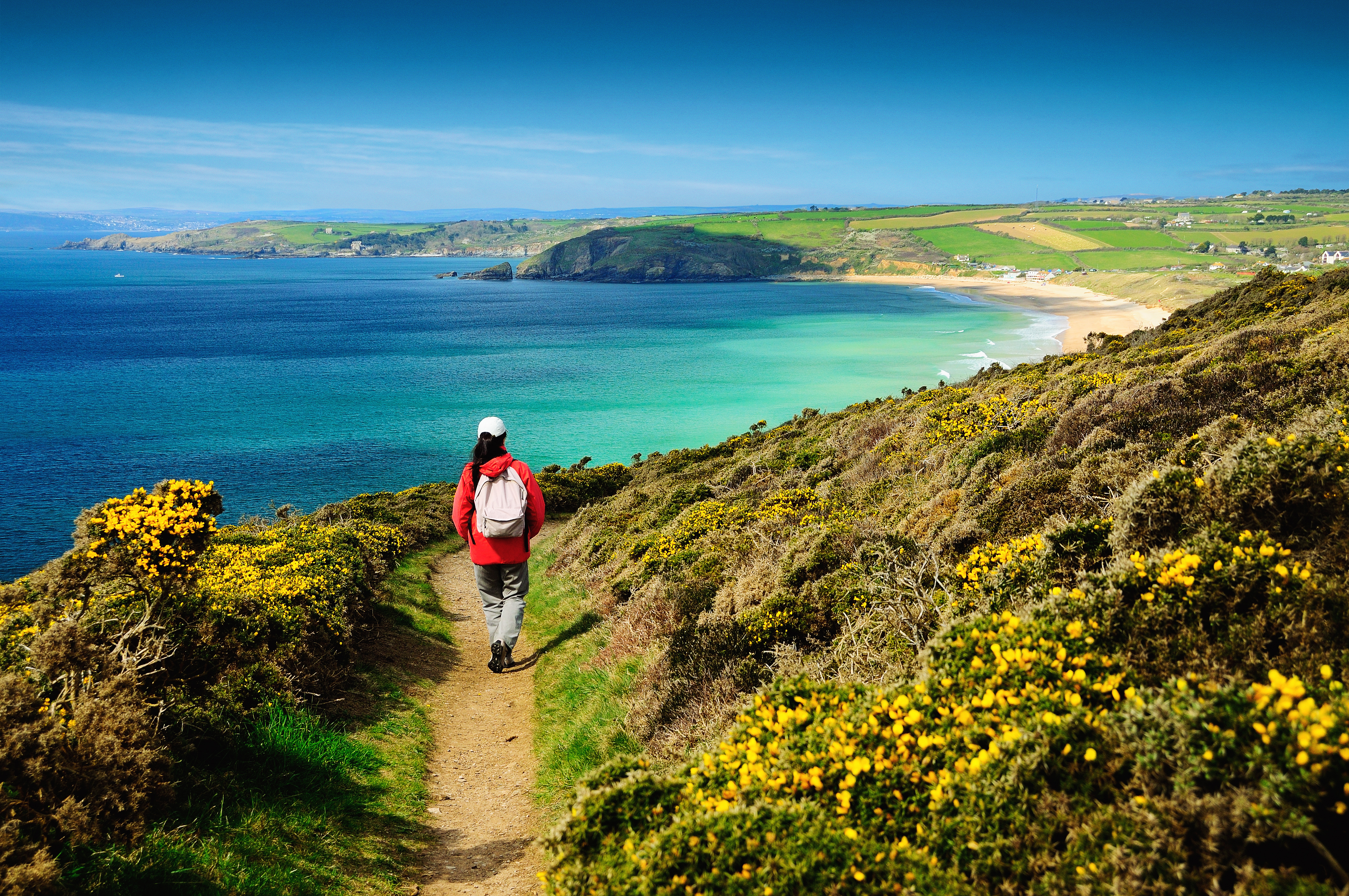 A person on a footpath on the coastal path near sea