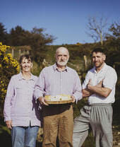 Bauern posieren mit frischem Bauernkäse auf der Pant Mawr Farm