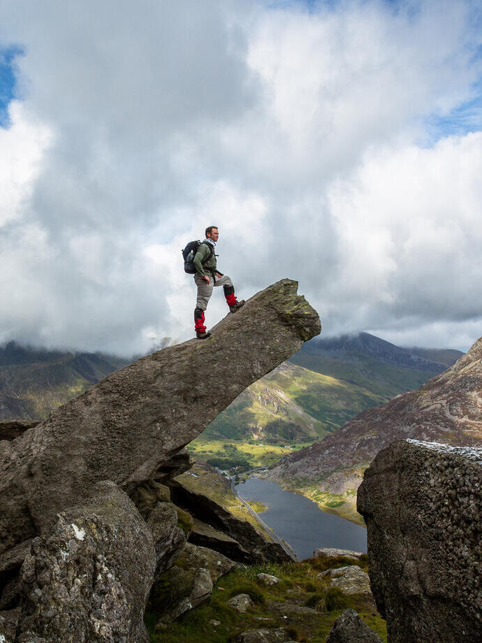 Un homme debout sur un rocher en saillie, admirant la vue