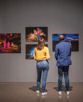 A woman and a man stand looking at an exhibition