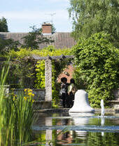 A couple sitting by a water fountain in Leicester's Botanic Gardens