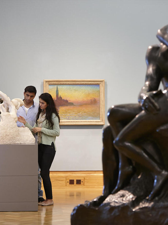 Uomo e donna che osservano opere d'arte in un museo