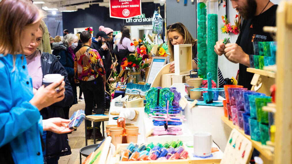 Gente comprando baratijas en un mercado de artesanía.