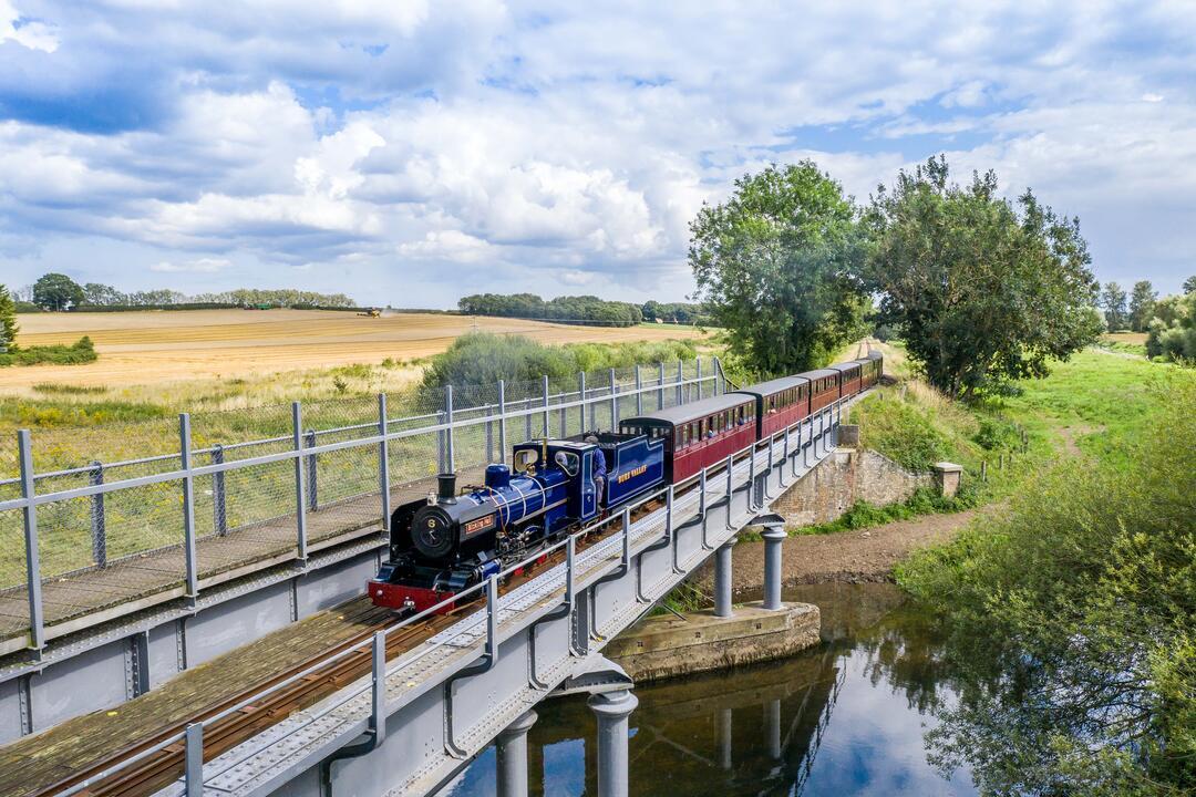 A steam train passing over a river in the Broads National Park